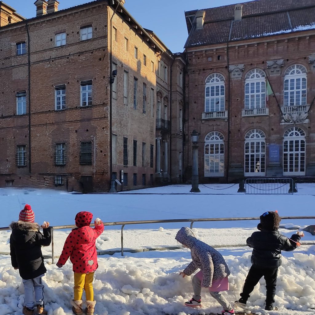 I bambini giocano con la neve davanti al Castello di Agliè